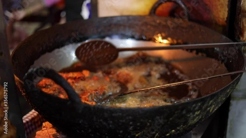 Deep frying chicken in an India Kadhai at a street food market in Zakir Nagar, Delhi photo