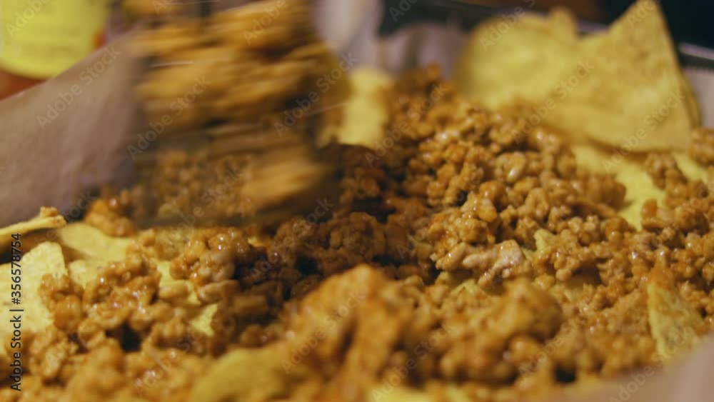 Laying minced meat on nacho chips Laying minced meat on nacho chips