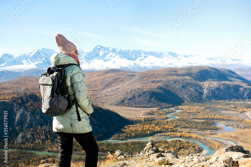 Adult woman hiking in the mountains. Hiker looking at panoramic landscape.