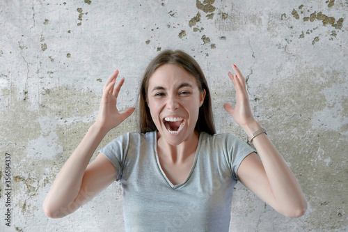 Angry woman screaming isolated on a concrete background photo