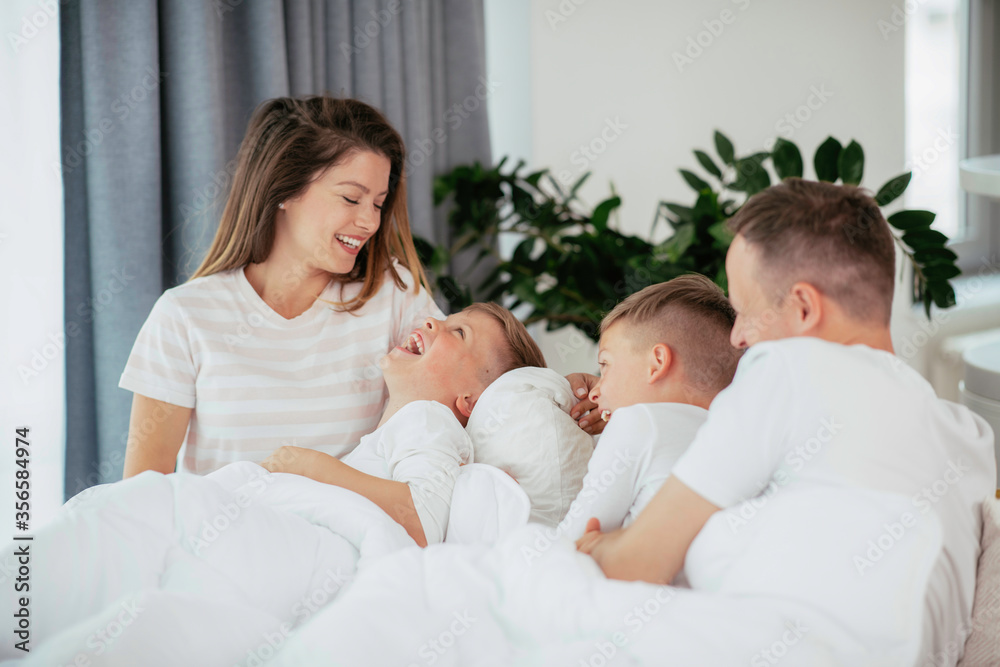 Young family enjoying at home. Happy parents with sons relaxing on sofa. Young family enjoying at home. Happy parents with sons relaxing on sofa.