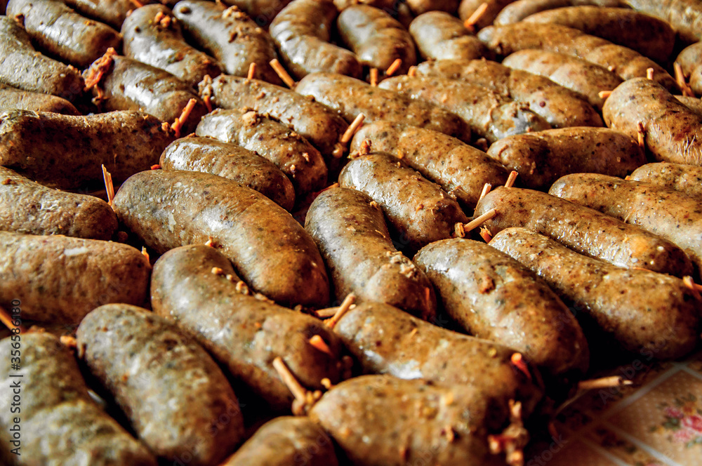 Many small grilled sausage on table.