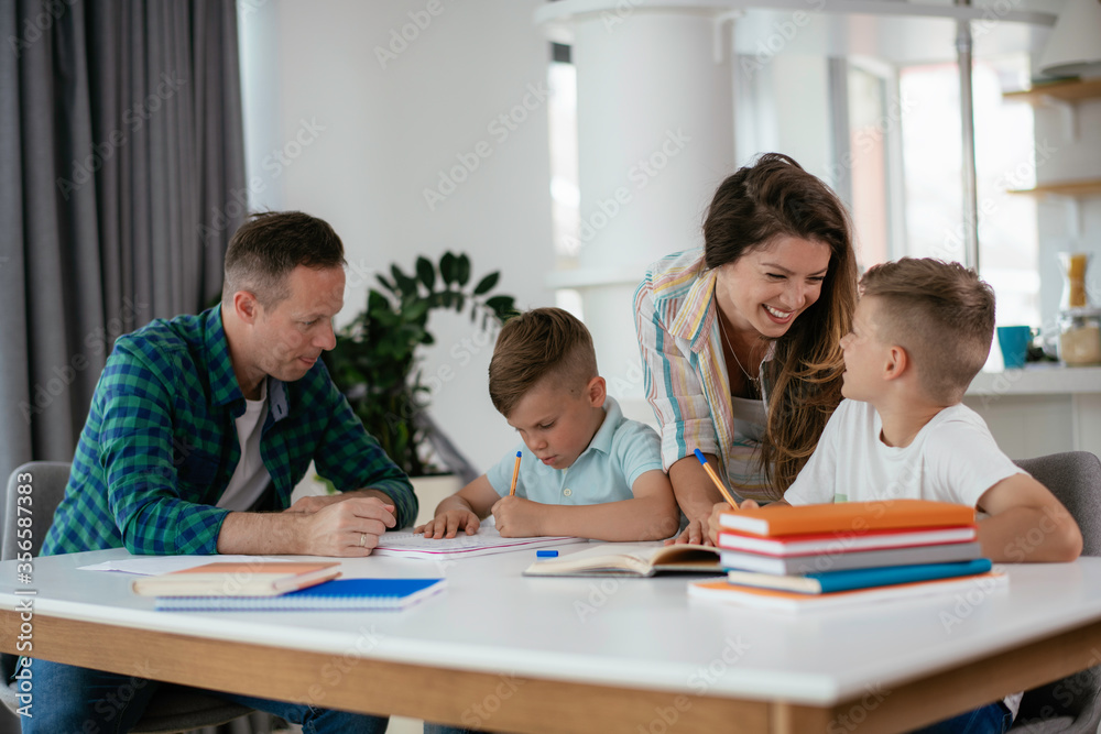 Parents helping the kids with their homework. Litlle boys learning at home. Parents helping the kids with their homework. Litlle boys learning at home.