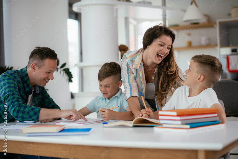 Parents helping the kids with their homework. Litlle boys learning at home. Parents helping the kids with their homework. Litlle boys learning at home.