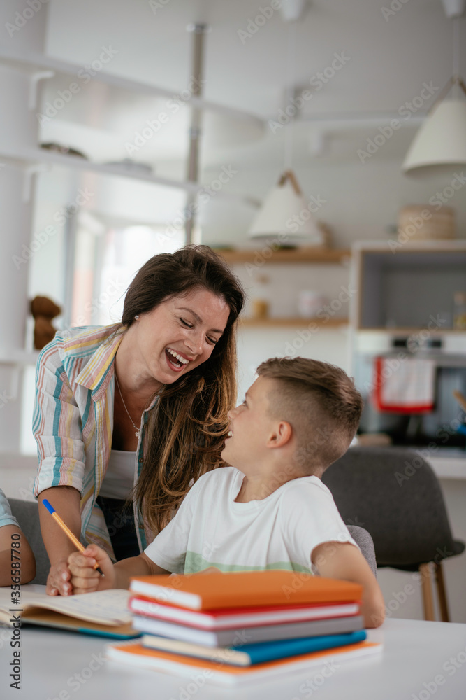 Mother helping her son with homework at home. Little boy learning at home. Mother helping her son with homework at home. Little boy learning at home.