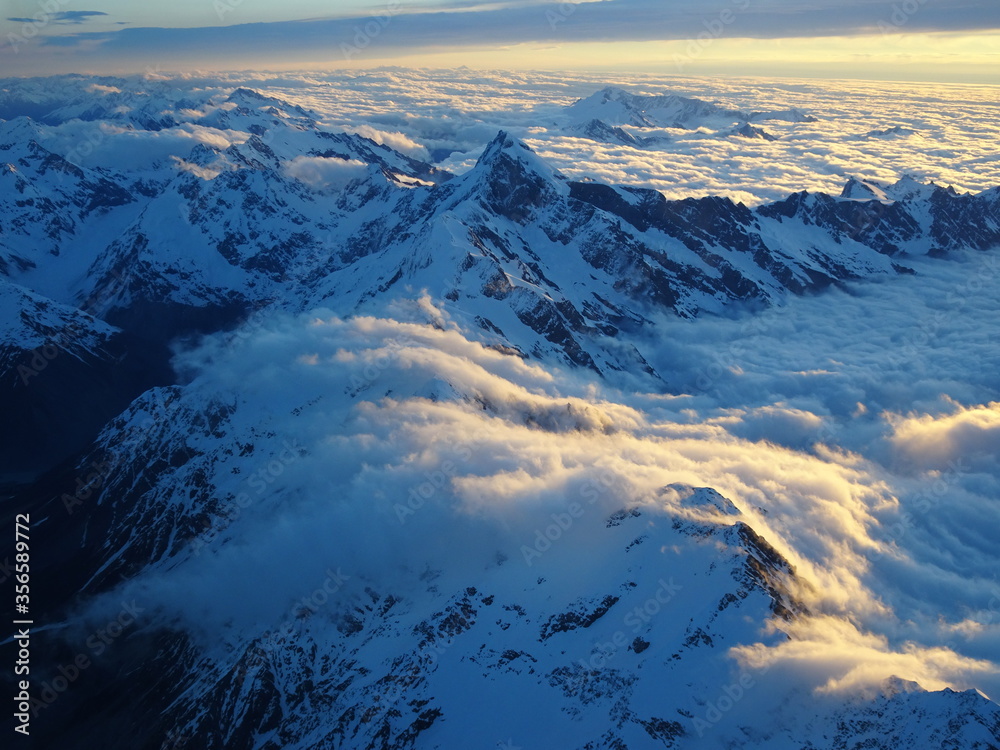 En Nouvel Zélande, près du Mont Cook, observation de nuages débordant de leur lit de montagne lors d'un coucher de soleil. 