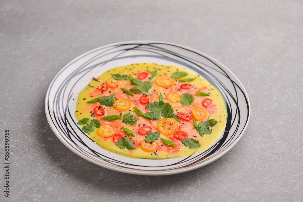 Chilled cucumber avocado soup with salmon fish, tomato, pepper, fresh greenery served in a plate over gray background. Chilled cucumber avocado soup with salmon fish, tomato, pepper, fresh greenery served in a plate over gray background.