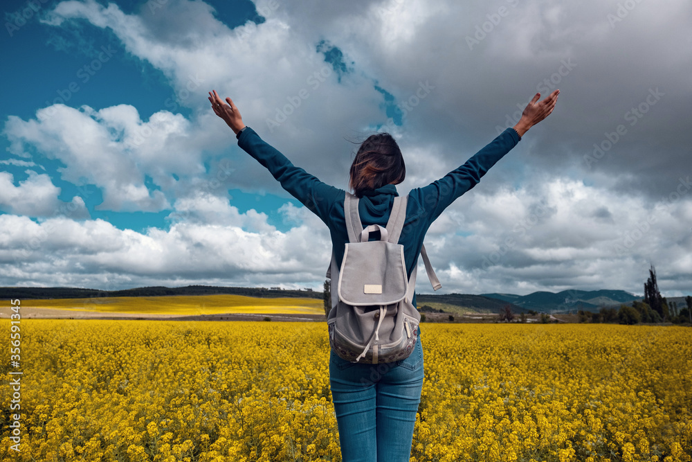 Woman traveler in a flowering rapeseed field. Woman traveler in a flowering rapeseed field.