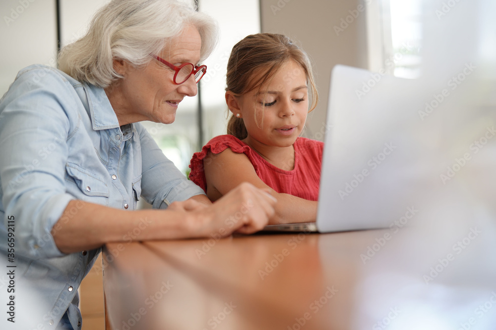 Grandmother with little girl using laptop at home Grandmother with little girl using laptop at home
