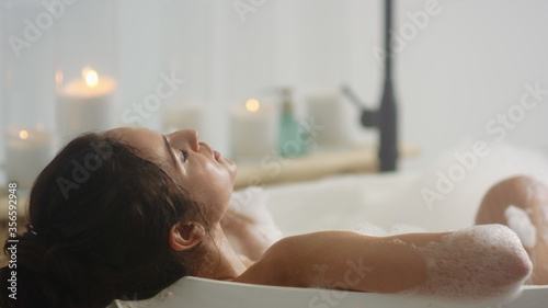 Stampa su tela Close up relaxed woman lying in bath foam