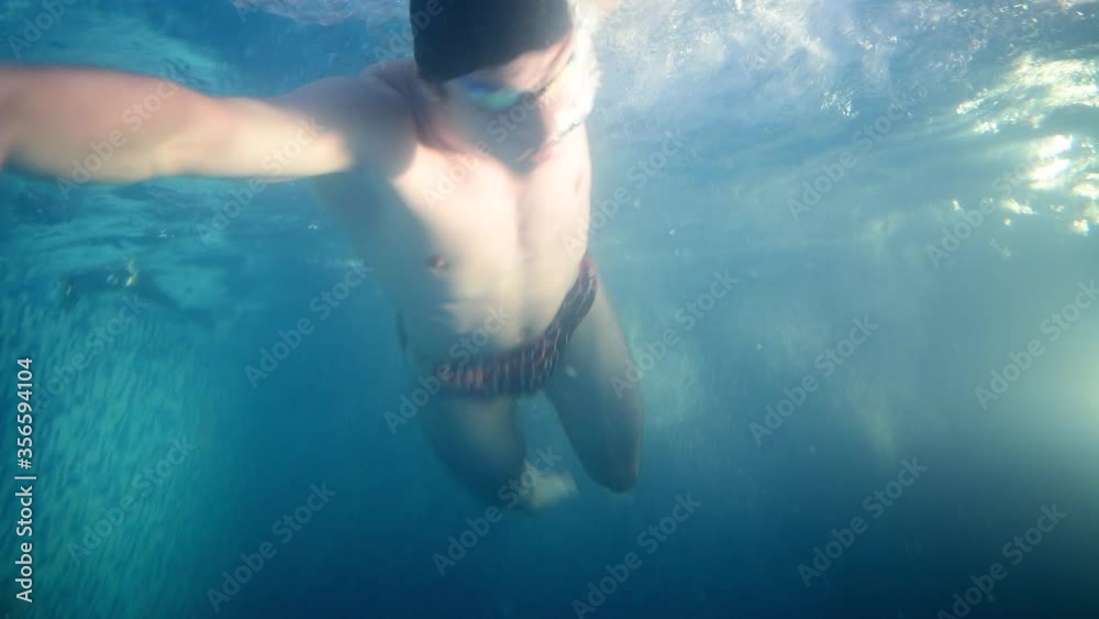Underwater view professional swimmer in swimming pool, training workout action 