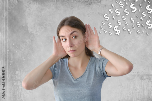 Young beautiful woman with hand over ears with dolar comming