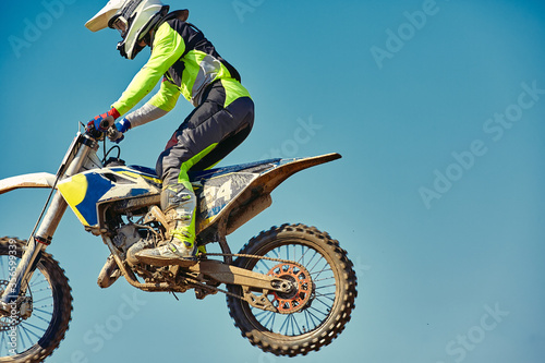 Motocross concept  a biker goes off-road making extreme skiing. In pursuit of adrinalin  sport concept. Dangerous sport.