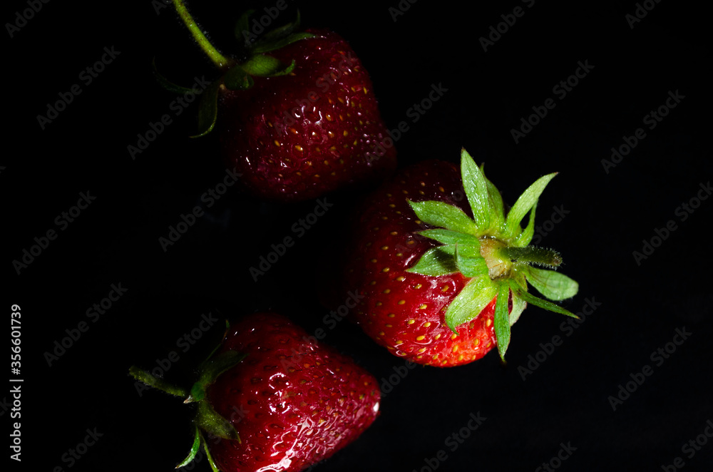 fresh strawberries on a black background fresh strawberries on a black background