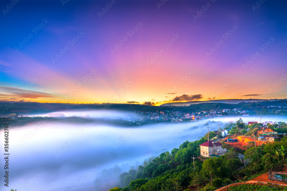 Beautiful dawn impressed by rays shine into sky shone misty valley covered all the magical landscape created in highlands of Da Lat, Vietnam