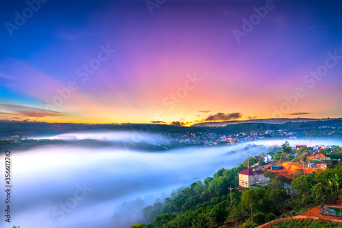 Beautiful dawn impressed by rays shine into sky shone misty valley covered all the magical landscape created in highlands of Da Lat, Vietnam © huythoai