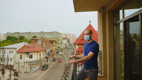 Lonely man with mask on terrace during coronavirus isolation. © DC Studio
