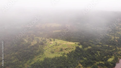 Aerial drone view of flying through clouds in mountains and fields, Maharashtra, India photo