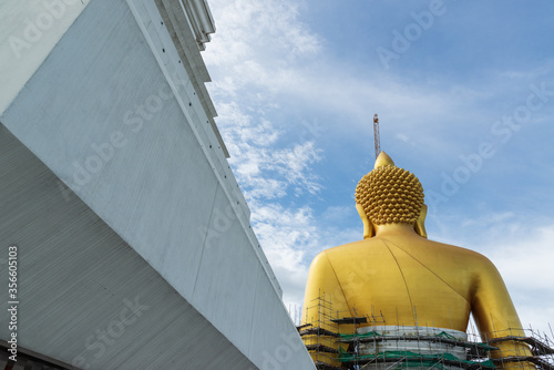 Big golden buddha image meditation poster named (Phra Buddha Dhammakaya Thepmongkhon) under construction at Wat Paknam Bhasicharoen, Bangkok, Thailand. photo