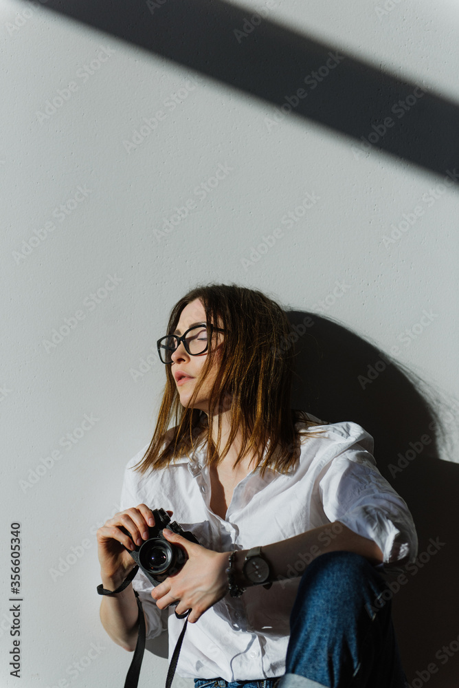 Beautiful young woman with a camera at home. Beautiful young woman with a camera at home.