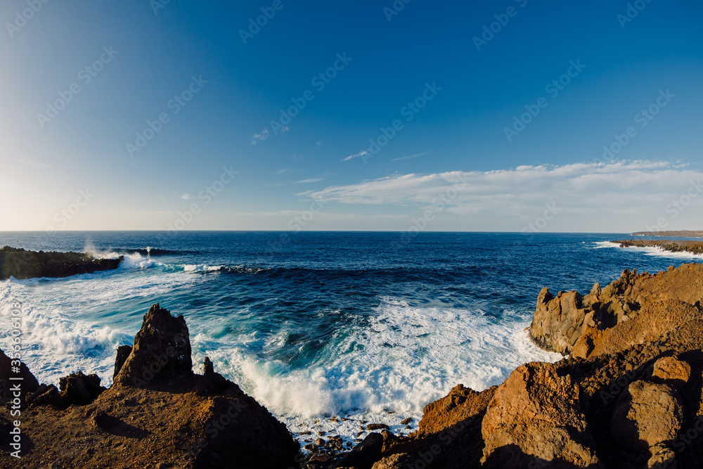 Coastline with lava cliffs and ocean waves in Canary Islands.