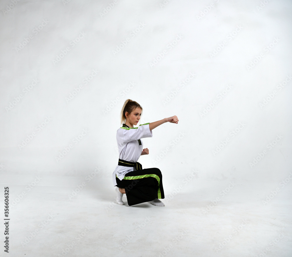 beautiful girl fighter in black and white kimono does exercises in the style of martial arts beautiful girl fighter in black and white kimono does exercises in the style of martial arts