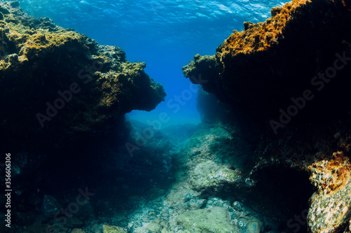 Underwater view with rocks in blue ocean