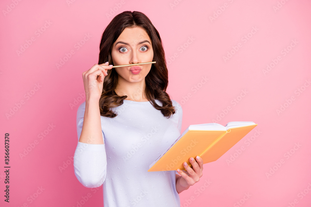Photo of attractive student lady hold personal planner writing school college homework playing with pencil make fake mustache funny wear casual white pullover isolated pink color background Photo of attractive student lady hold personal planner writing school college homework playing with pencil make fake mustache funny wear casual white pullover isolated pink color background