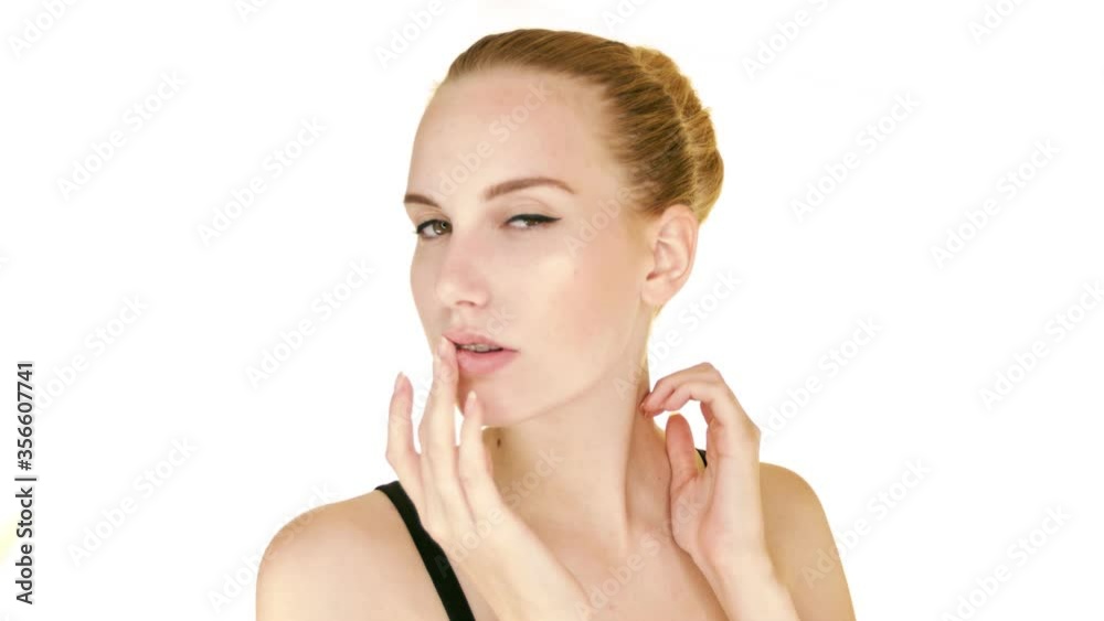 Beautiful sexy blonde model gently touches her face. Closeup portrait on a white background. Beautiful sexy blonde model gently touches her face. Closeup portrait on a white background.
