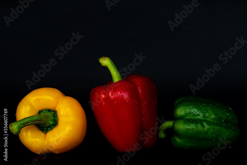 frische Paprika mit Wassertropfen rot gelb grün vor schwarz photo