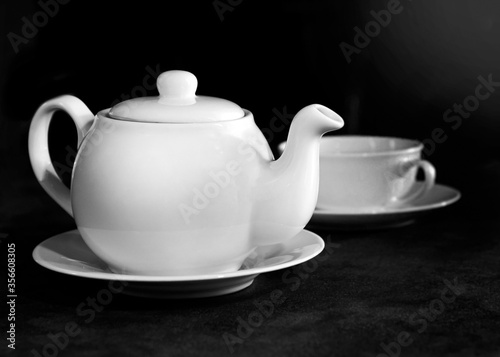White porcelain tea cup and teapot, Afternoon tea table setting Black & White.