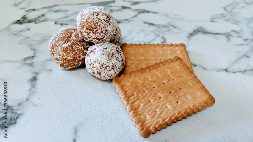 Chocolate and biscuits balls with coconut flacks with two whole