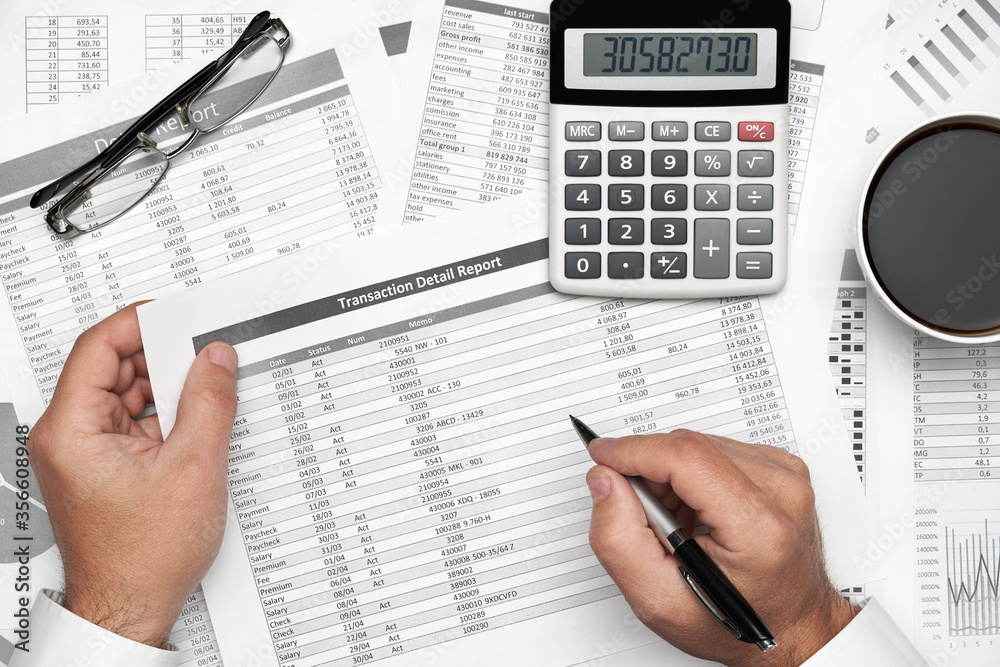 Top view of businessman working with financial statements. Modern black office desk with notebook, pencil and a lot of things. Flat lay table layout. Top view of businessman working with financial statements. Modern black office desk with notebook, pencil and a lot of things. Flat lay table layout.