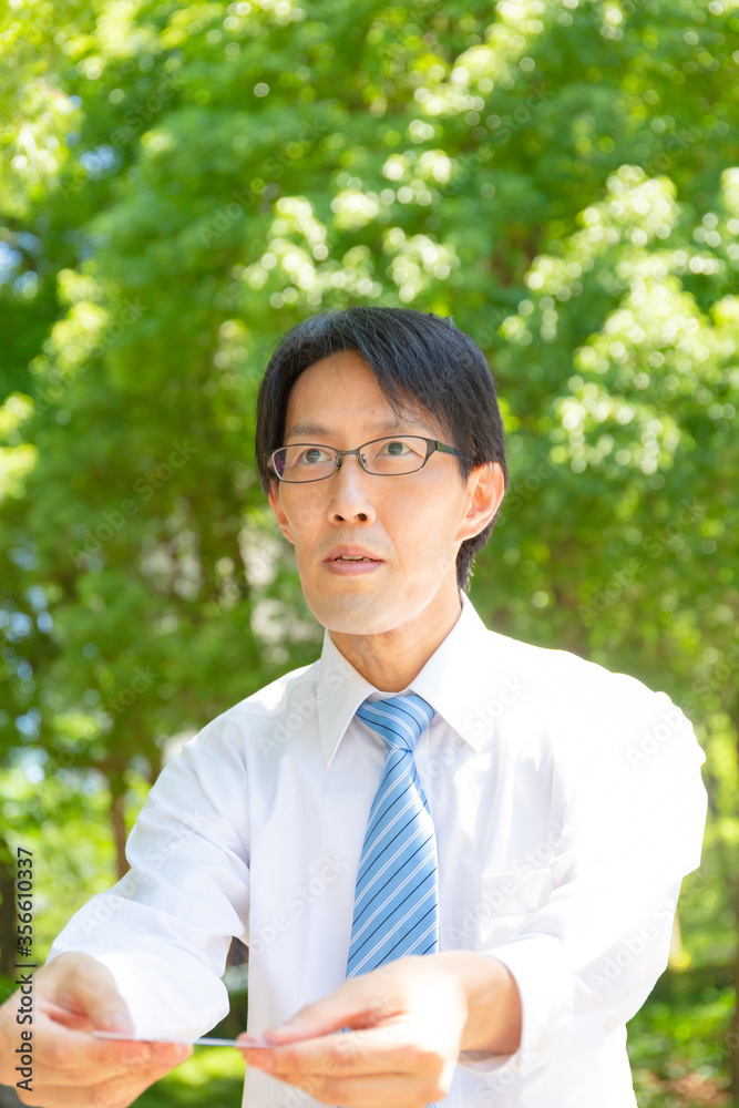 やせ型の真面目そうな日本人ビジネスマンが名刺を交換している やせ型の真面目そうな日本人ビジネスマンが名刺を交換している