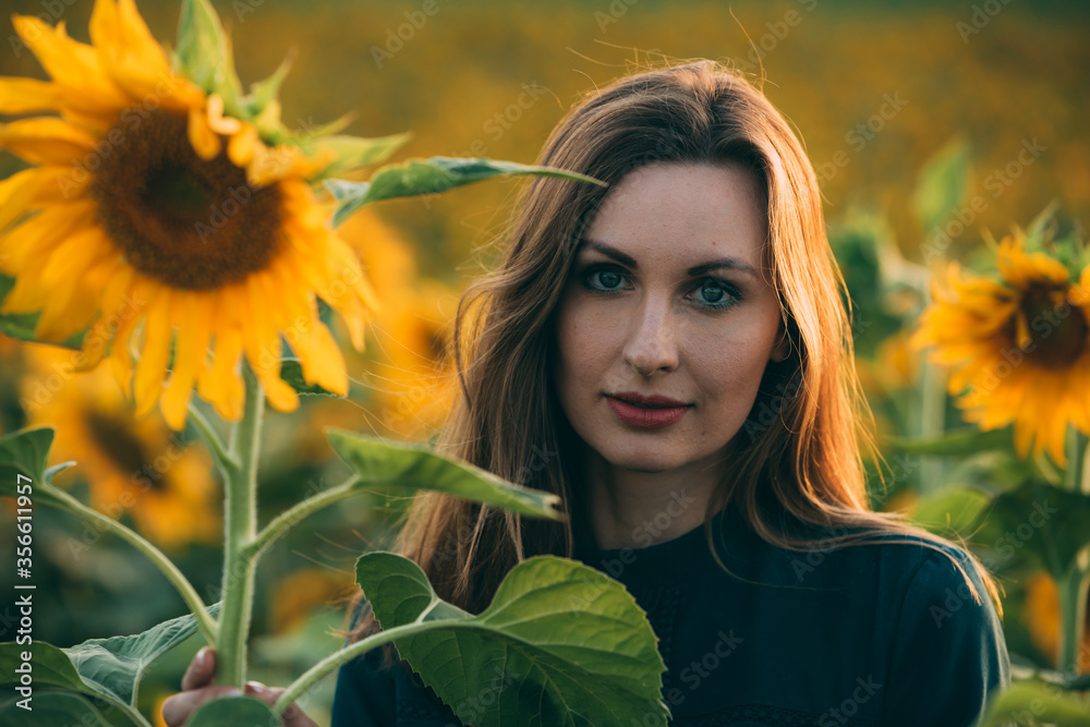Girl in a green dress and long blond hair in a sunflower field, enjoys the moment. The concept of summer and sun. Sunflower season in Israel. Celebrating life. Girl in a green dress and long blond hair in a sunflower field, enjoys the moment. The concept of summer and sun. Sunflower season in Israel. Celebrating life.