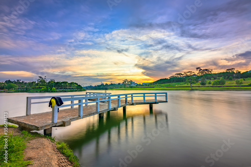 Sunrise on the small bridge overlooking the lake with the dramatic sky welcomes new day in the tourist city of Vietnam
