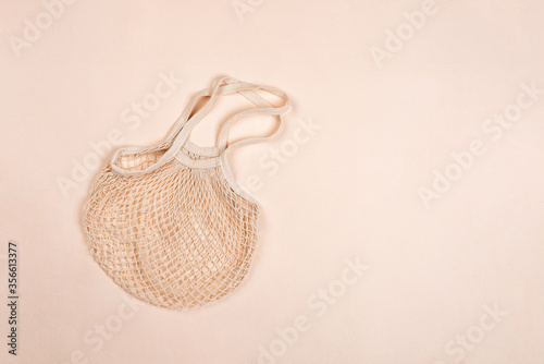 Cotton reusable bag on a beige canvas background. Eco-friendly concept. Flat lay, copy space