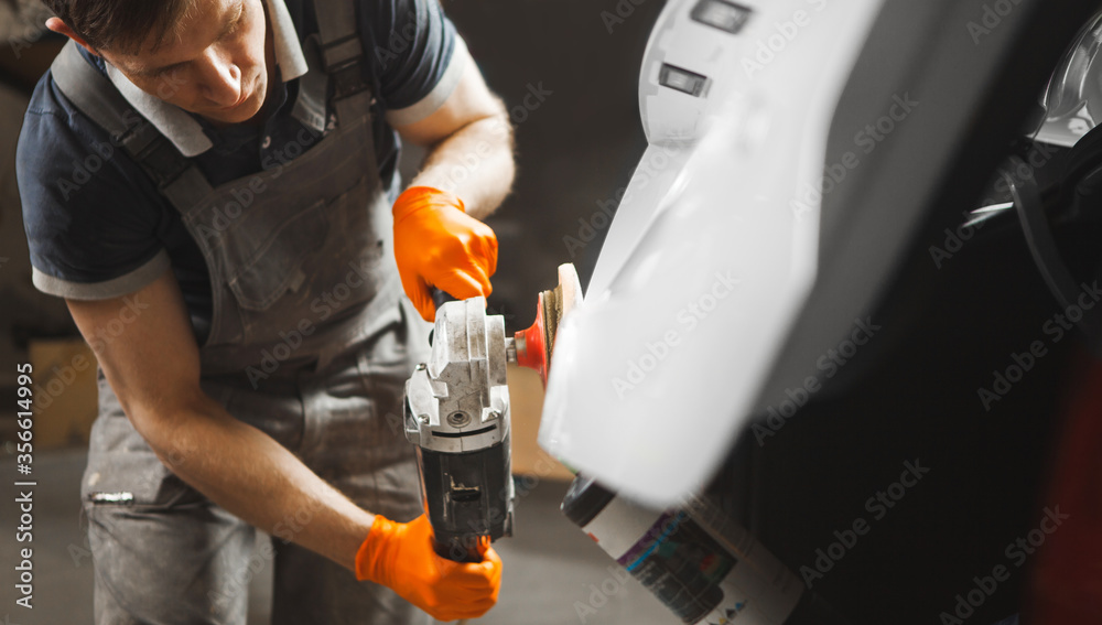 Car detailing. Close up of man with orbital polisher in auto repair shop. Car detailing. Close up of man with orbital polisher in auto repair shop.
