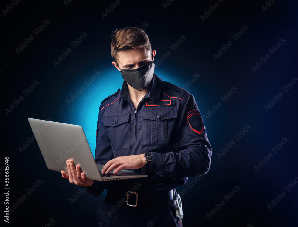 a handsome guy in a police uniform with a laptop on his face and a medical mask . a handsome guy in a police uniform with a laptop on his face and a medical mask .