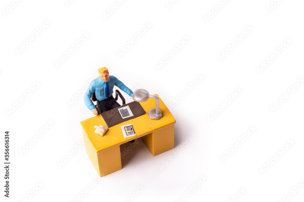Miniature businessman behind desk at the office Miniature businessman behind desk at the office