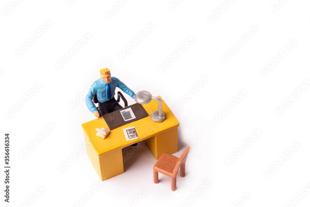 Miniature businessman behind desk at the office Miniature businessman behind desk at the office