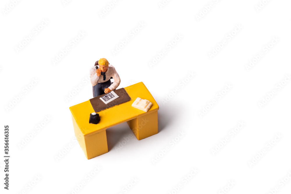 Obraz premium Miniature businessman behind desk at the office