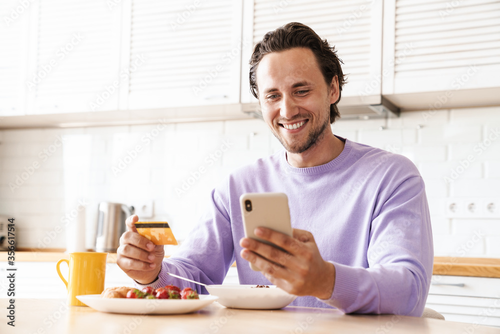 Attractive young man sitting at the kitchen table Attractive young man sitting at the kitchen table