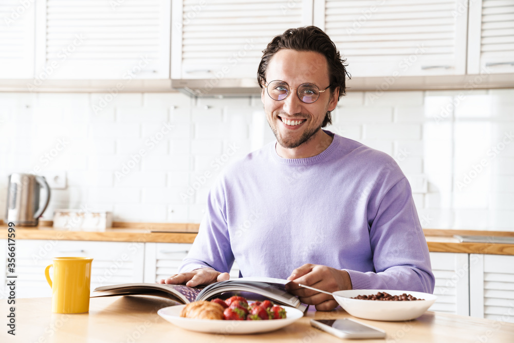 Attractive young man sitting at the kitchen table Attractive young man sitting at the kitchen table