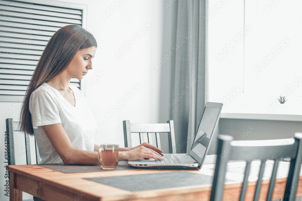Girl working on computer laptop in light room Girl working on computer laptop in light room