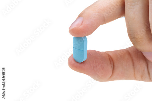 hand of a man holding a pill, isolated on white background