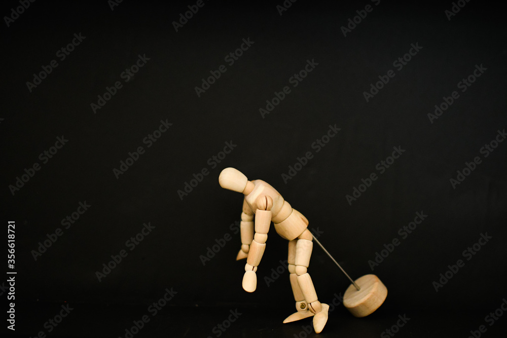 wooden mannequin in the dark background looking down wooden mannequin in the dark background looking down