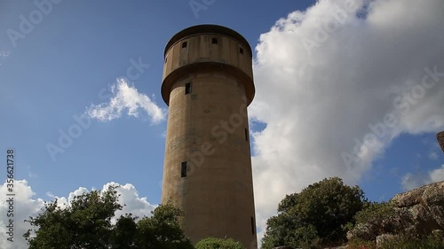 Luras - Italy, June 2020. Tower water tank, timelapse clouds and blue sky photo