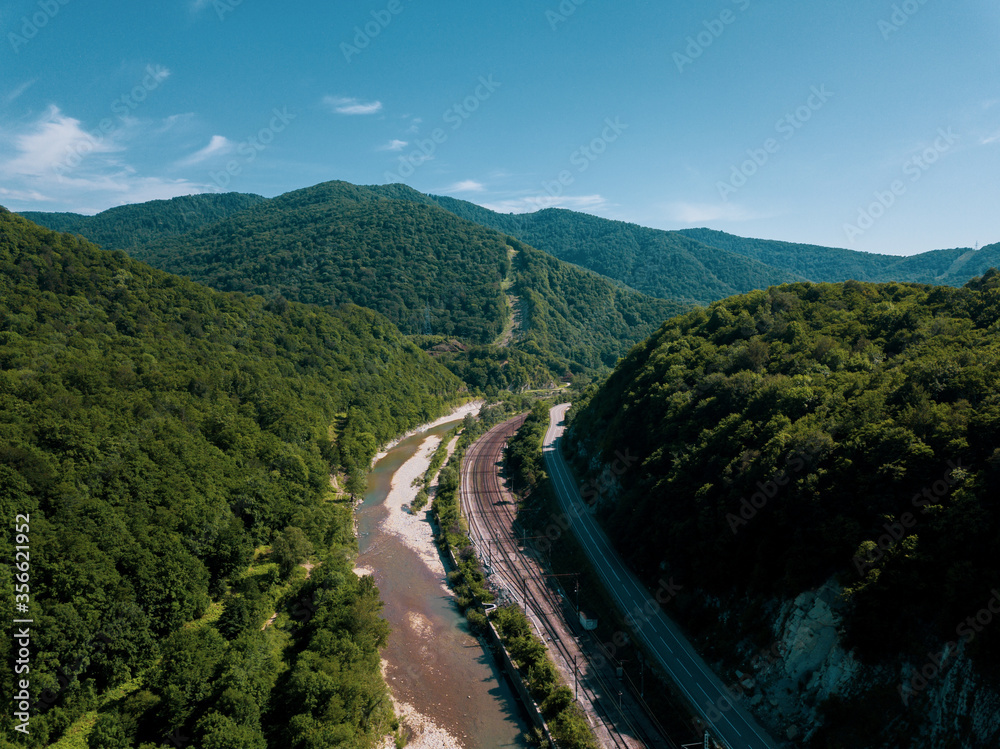 Aerial view of highway and railway between the greenmountains