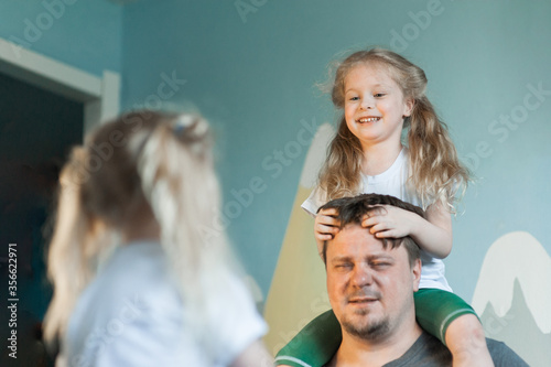 dad plays at home with his children: daughters, son